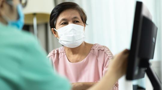 Doctor and older female patient in medical office looking at computer monitor