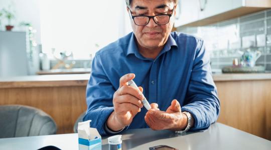 Man using a glucose meter to test his blood sugar levels