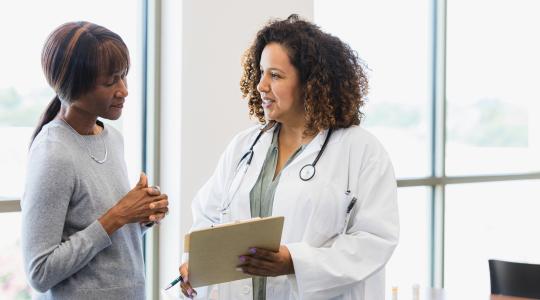 Woman physician talking to woman patient
